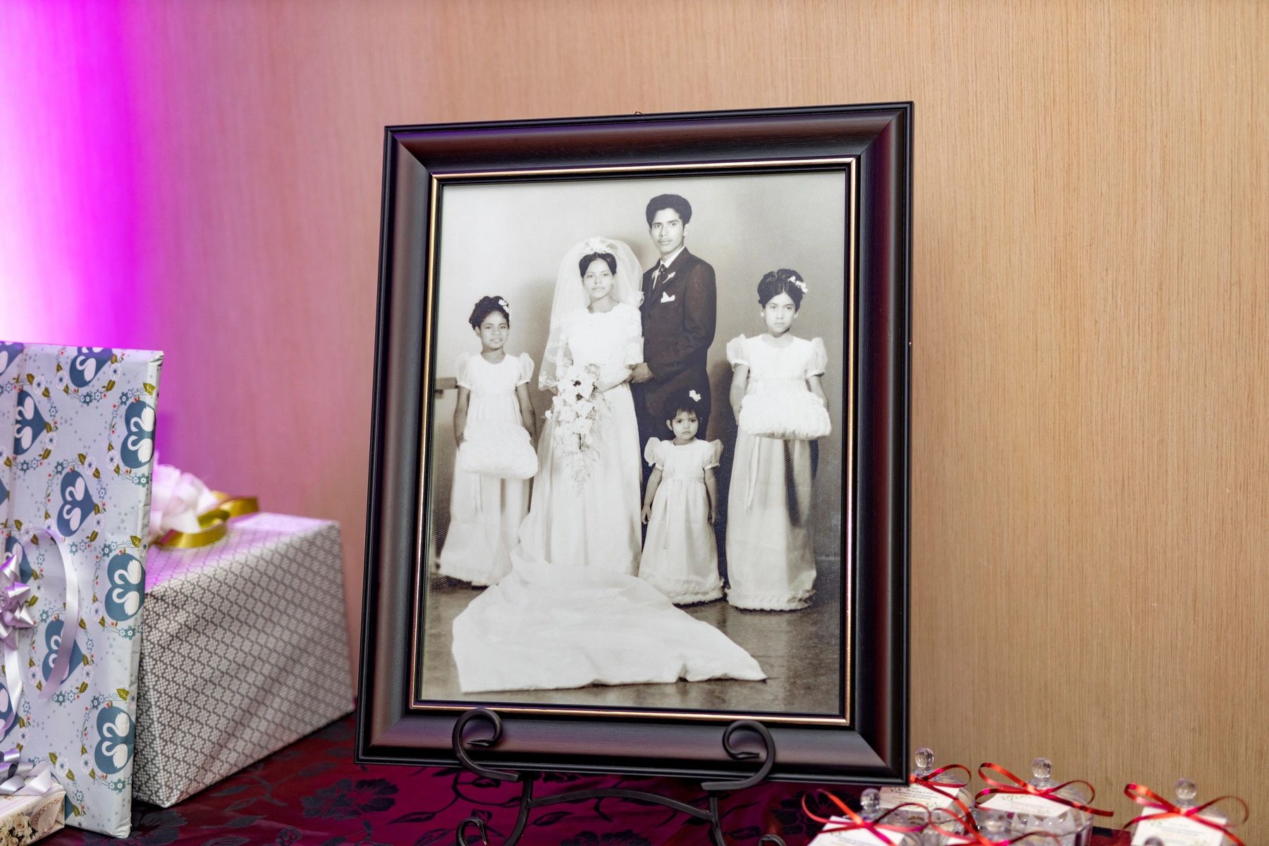 Framed black and white vintage wedding photo with bride, groom, and flower girls.