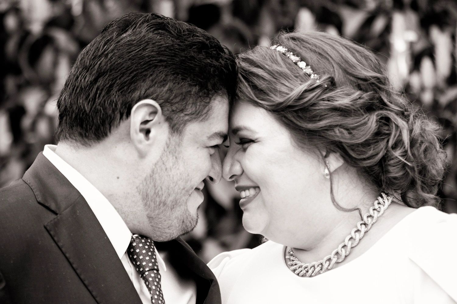 A couple sharing a joyful and intimate moment, touching foreheads and smiling.