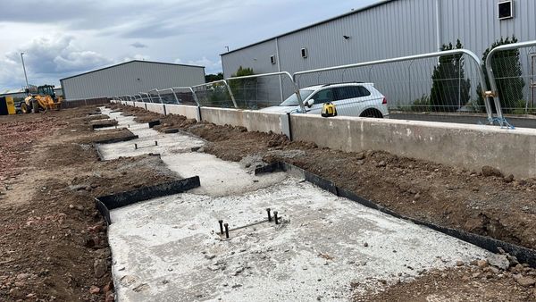 Concrete foundation installation with ground beams and holding down bolts.