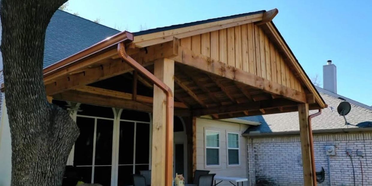 Western red cedar freestanding patio cover with shingled roof and gutters.