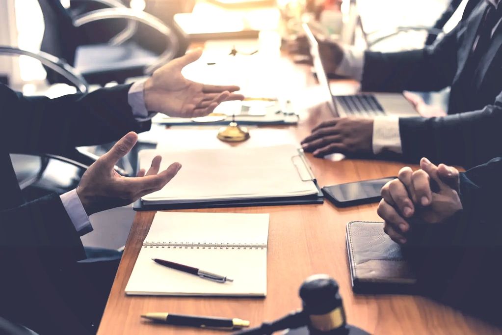 Business meeting with people discussing and taking notes at a conference table.