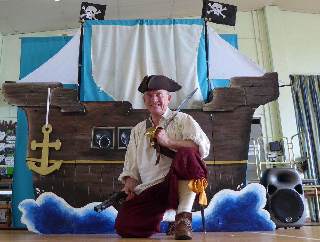 Pirate Ron kneeling in front of his pirate ship.