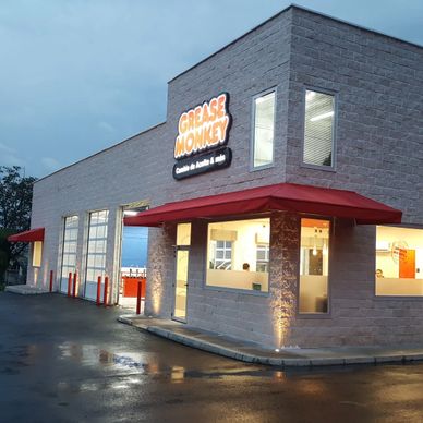 Exterior view of a Grease Monkey auto service center at dusk.