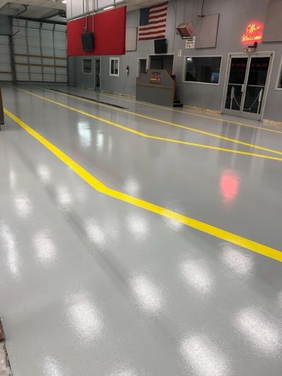 Clean, shiny garage floor with yellow safety lines and an American flag on the wall.