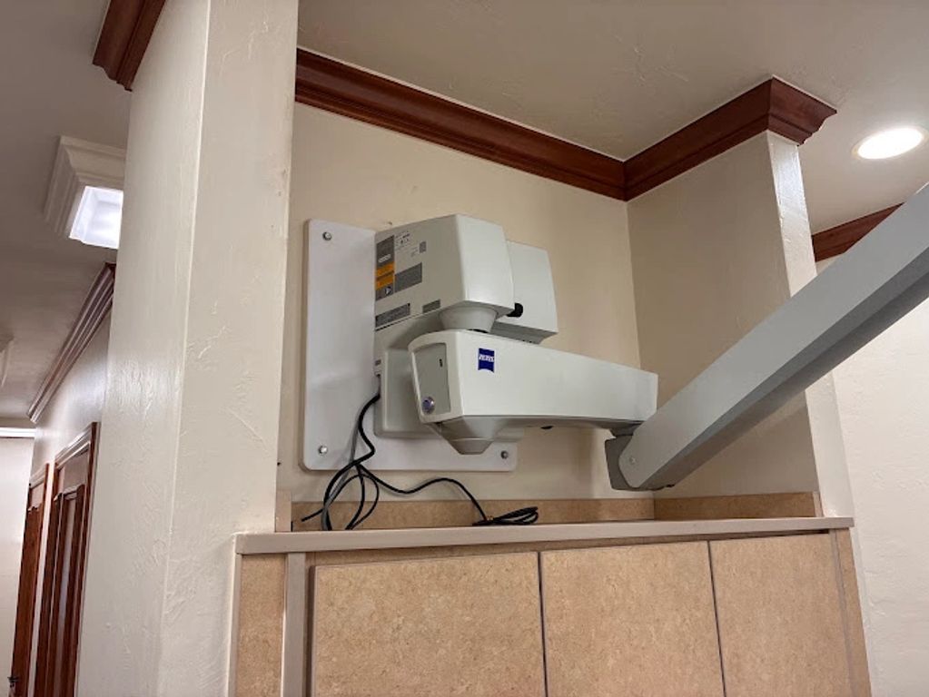 Wall-mounted medical equipment arm in a hallway corner.