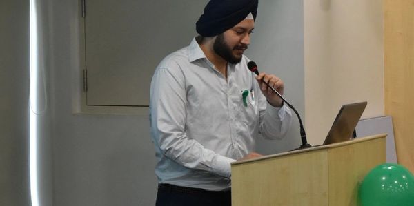 Man with turban speaking at a podium with a laptop.