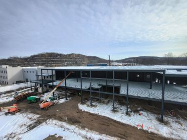 Construction site of a steel-frame building in a snowy area.