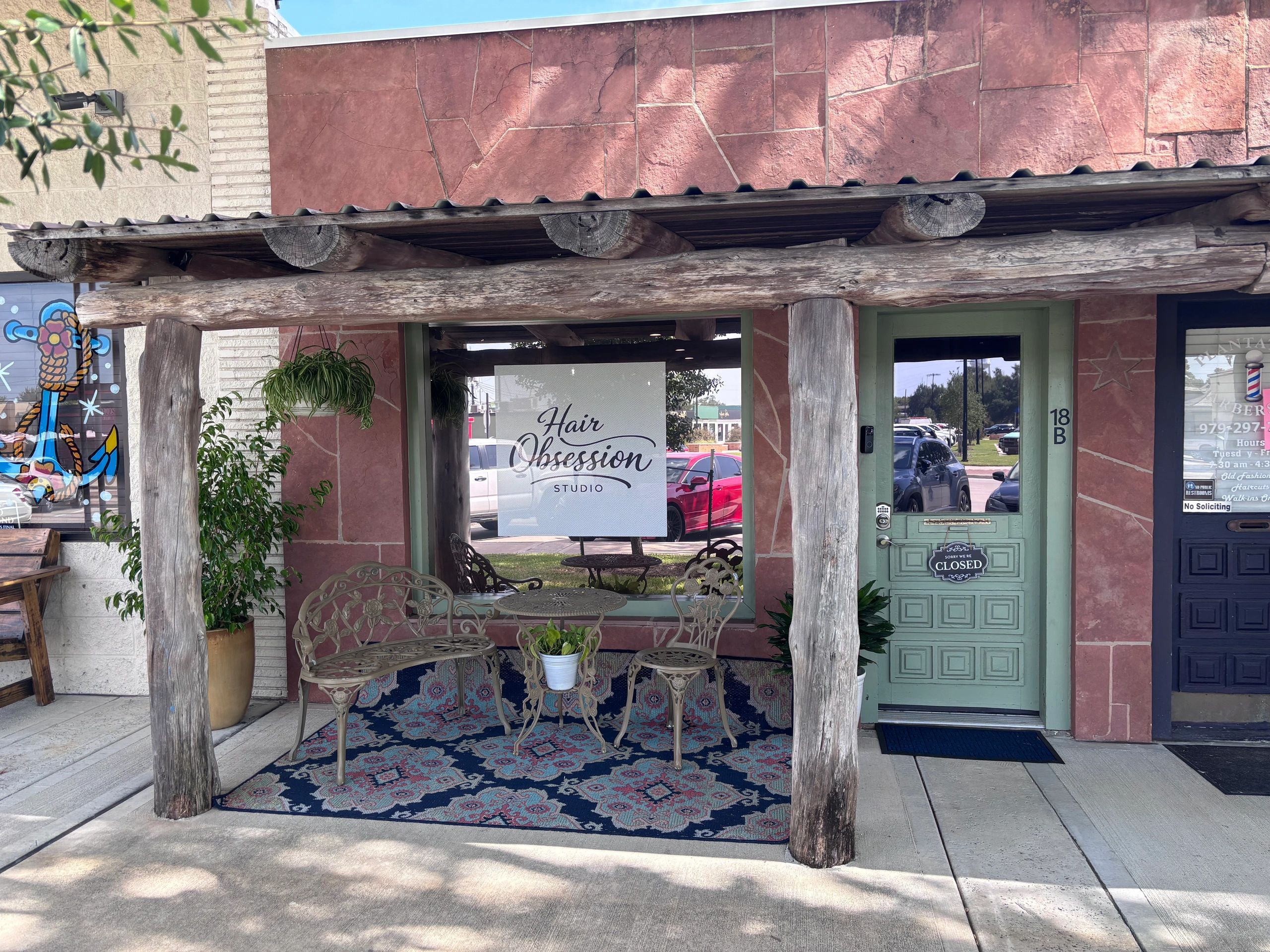 Hair Obsession Studio storefront with rustic wooden beams and outdoor seating.