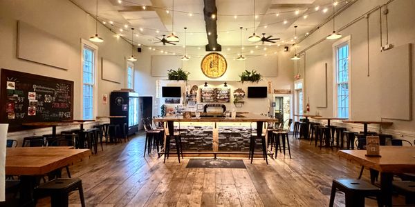 Cozy bar interior with wooden floors and string lights.