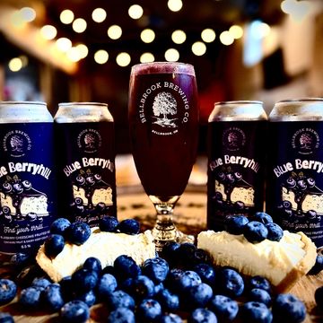 Blueberry beer with fresh blueberries and dessert on a wooden board.