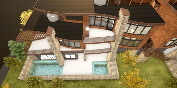 Aerial view of a modern house with two pools and glass windows.