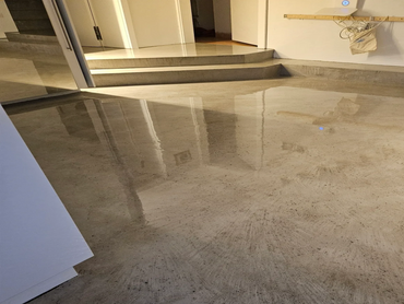 Hochglanzbeschichtung auf groben Sichtbeton im Farbton grau