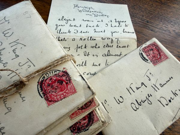 Old handwritten letters with red stamps tied with string.
