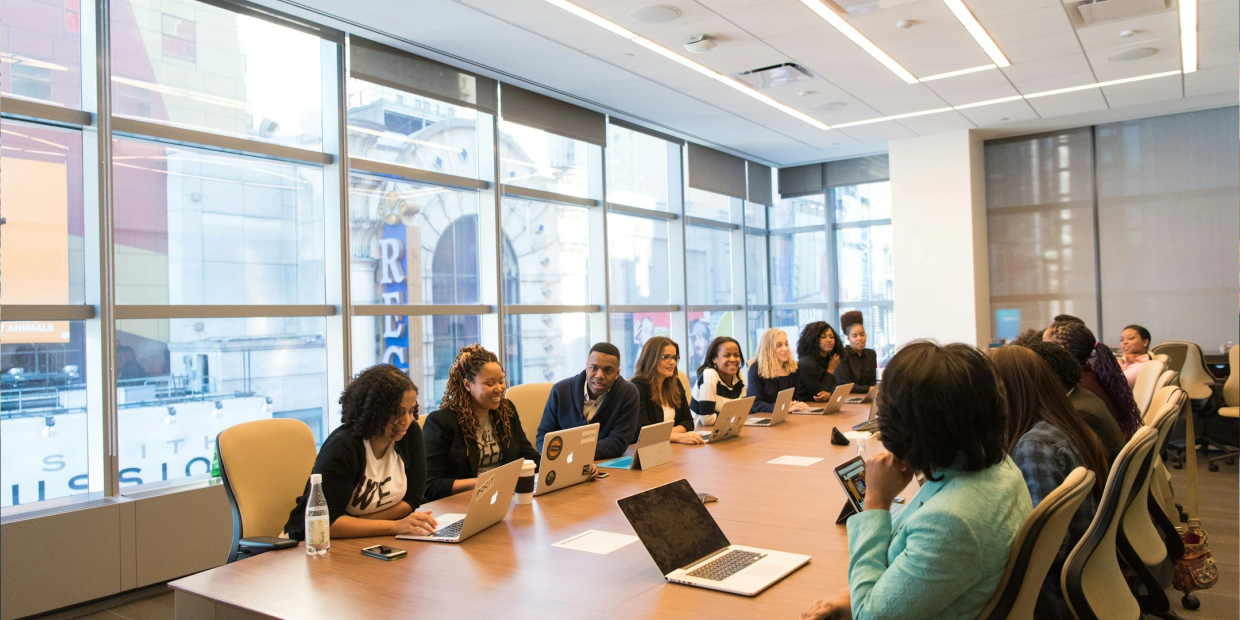 A diverse group of professionals engaged in a meeting around a conference table.
