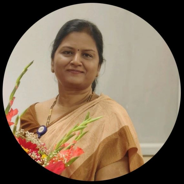Woman in traditional attire holding a bouquet of flowers, smiling gently.
