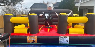 An inflatable mechanical bull ride setup outdoors.