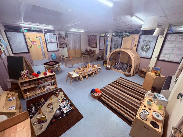 Cozy, organized children's playroom with various activity stations.