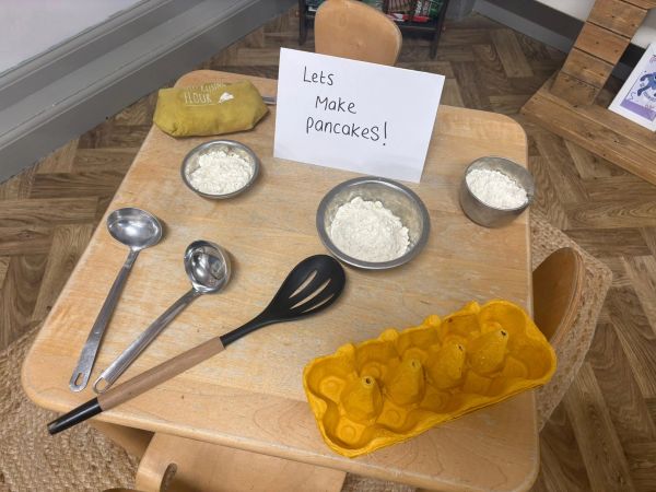 Table set with ingredients and tools for making pancakes.