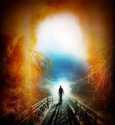 Person walking on a bridge towards a bright light.