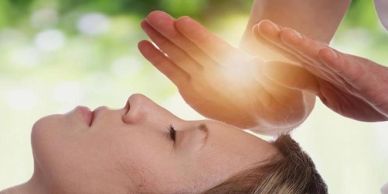 Person receiving energy healing with hands.