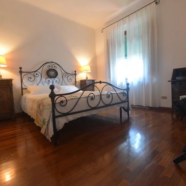 Cozy bedroom with ornate iron bed and warm lighting.