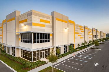 Modern commercial building with yellow accents and empty parking spaces.