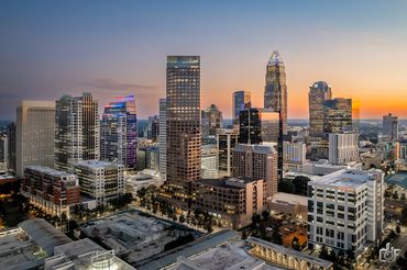 City skyline at sunrise with illuminated skyscrapers and vibrant colors.