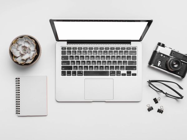 Computer, camera, and notepad on a social media managers desk