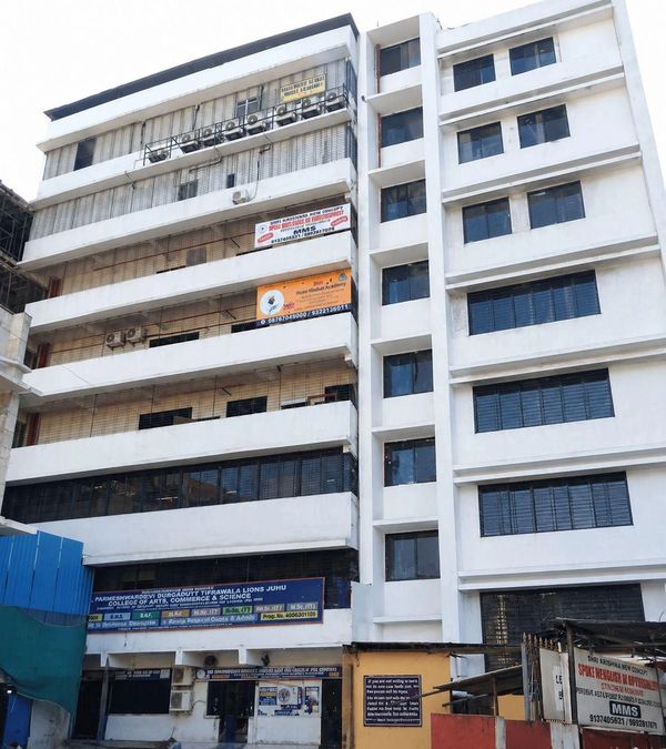 Multi-story educational building with various signs and air conditioners.