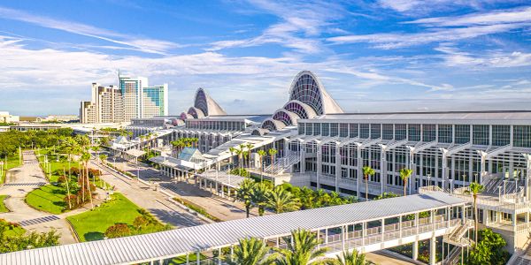 Modern convention center with skywalks under a partly cloudy blue sky.