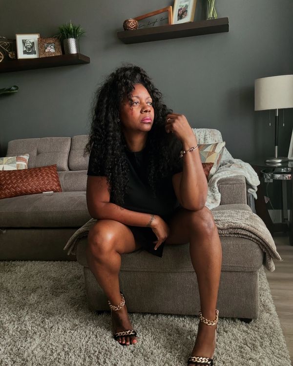 Woman sitting on an ottoman in a modern living room.