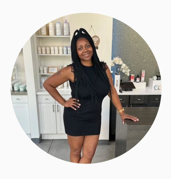 Woman in black dress smiling indoors.