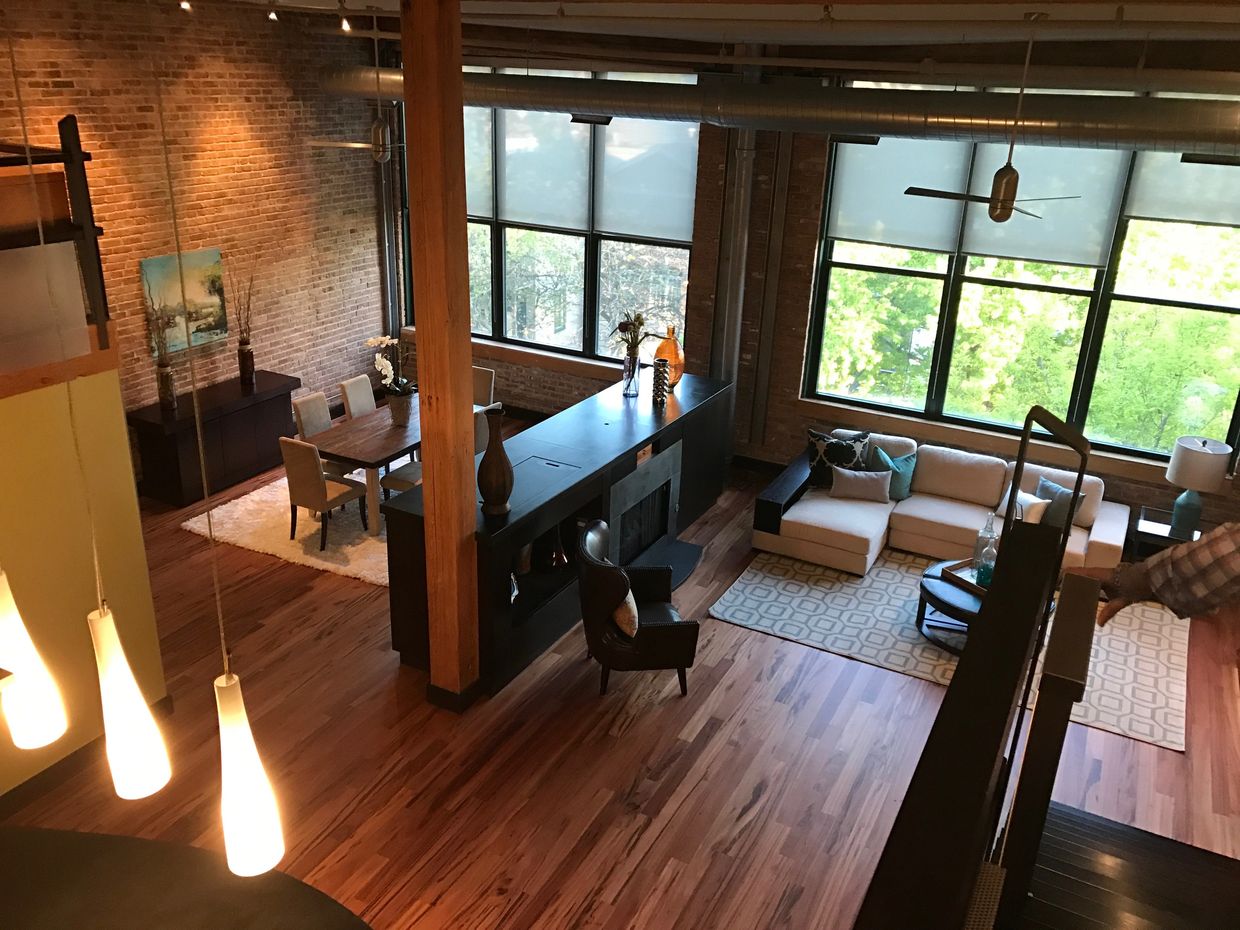 Spacious loft with wooden floors, large windows, and cozy living and dining areas.