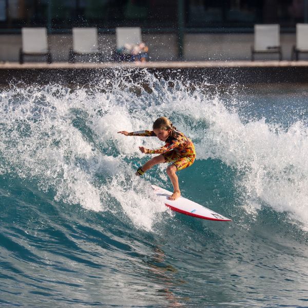 Young surfer riding a wave at the beach.