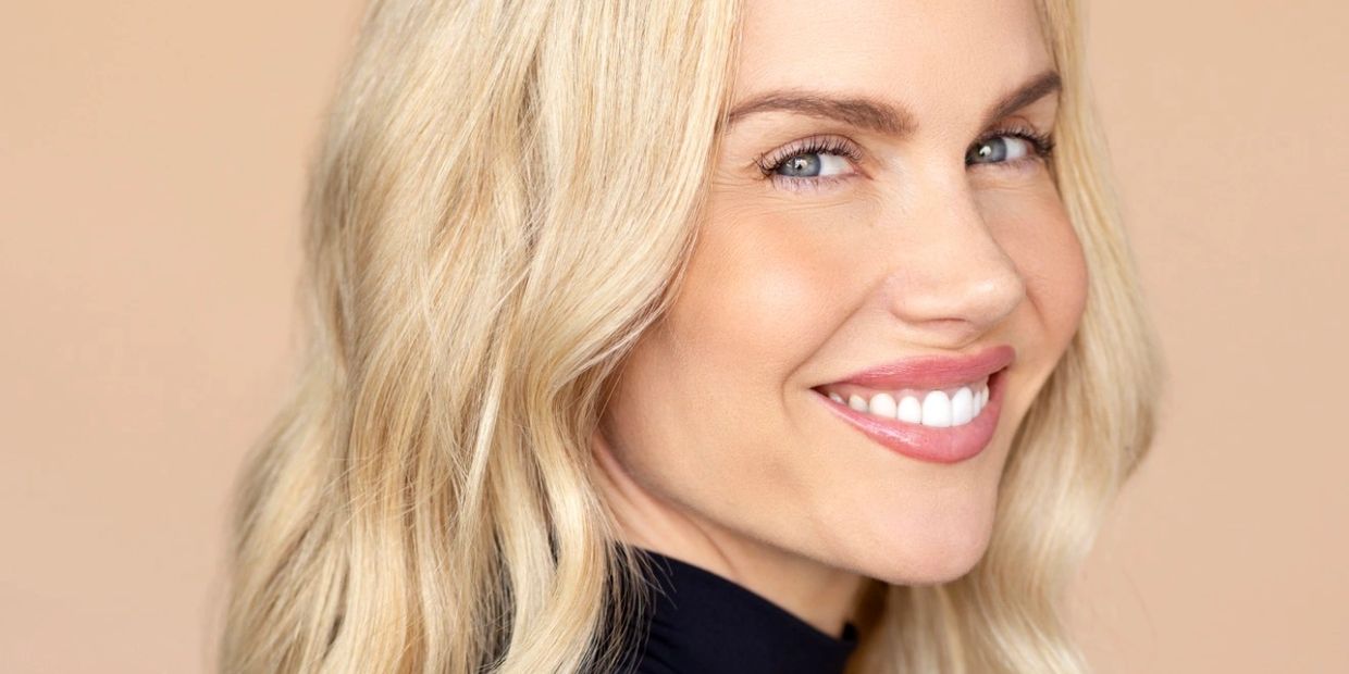 Close-up of a smiling blonde woman with blue eyes.