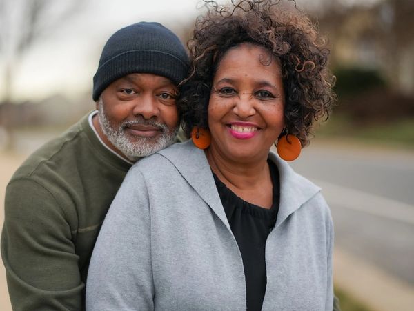 Smiling couple embracing outdoors on a cool day.