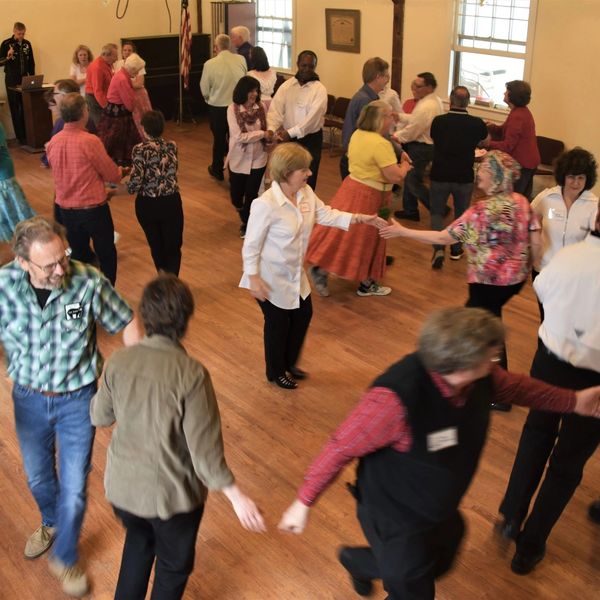 Group of people dancing in a hall.