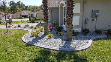 House landscaping with palm trees and gravel bed.