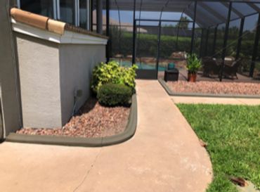 Outdoor patio area with plants and glass enclosure.
