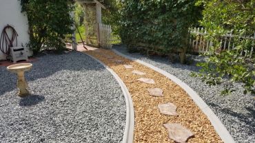 Curved garden path with stepping stones and gravel.