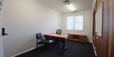 Minimalist office with two chairs and wooden furniture.