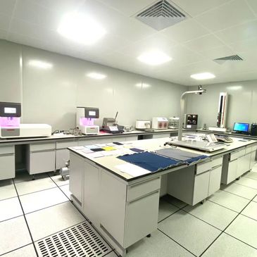 Bright, clean textile testing lab with fabric samples and advanced machines.