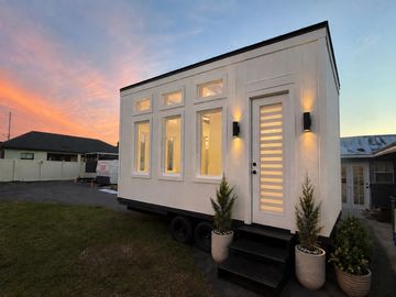 Modern tiny house on wheels at sunset.
