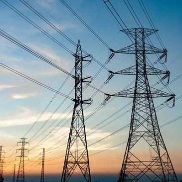 High-voltage power lines stretching across a scenic sunset sky.