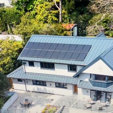 Modern house with solar panels on the roof under bright daylight.