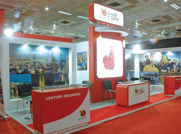 A vibrant exhibition booth promoting Spain with travel images and red-themed decor.