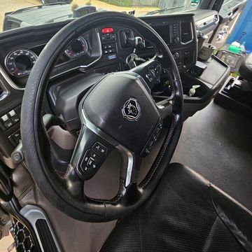 Interior of a truck showing the steering wheel and dashboard.