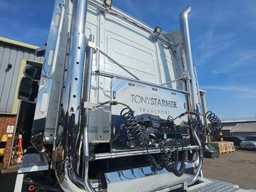 Back of a large white transport truck with coiled hoses.