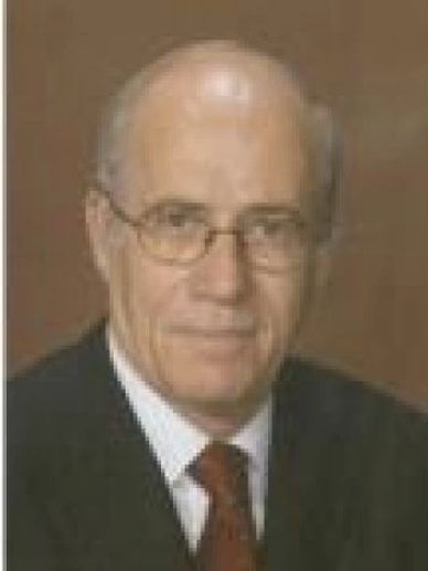 Professional portrait of an elderly man in a suit and tie.