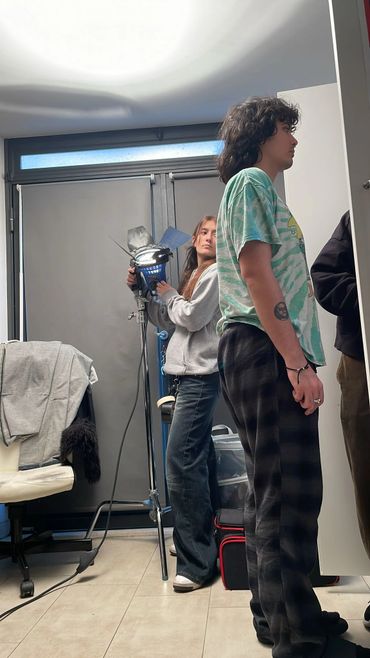Two people adjusting lighting equipment in a room with casual attire.